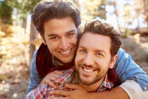 Portrait Of Gay Male Couple Walking Through Fall Woodland